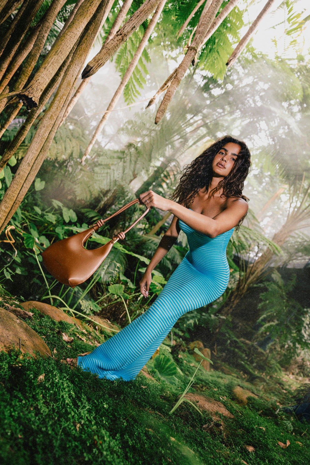 Mini leather crossbody bag with gold rings and adjustable knotted shoulder strap.