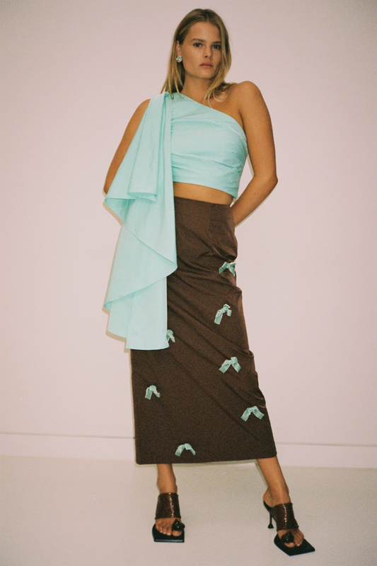 Brown high-waisted midi skirt with blue velvet bows by The Wolf Gang, styled to match the Amar One Shoulder Top.