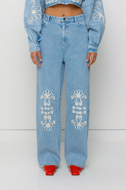 Vintage-inspired mid-rise barrel denim jeans with custom TWG embroidery and functional pockets, 100% cotton.