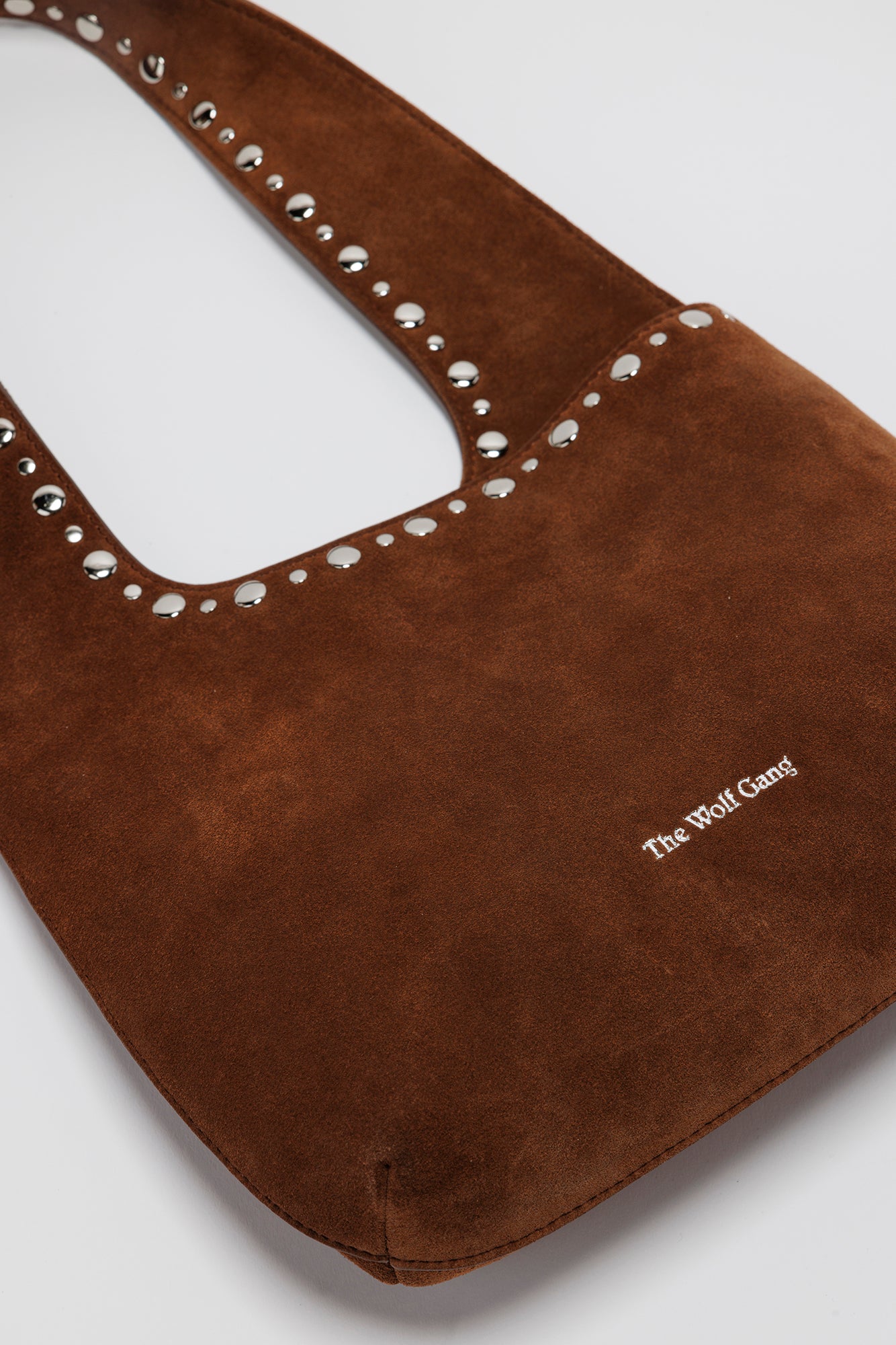 Luxe suede leather shoulder bag with magnetic closure and silver accents.