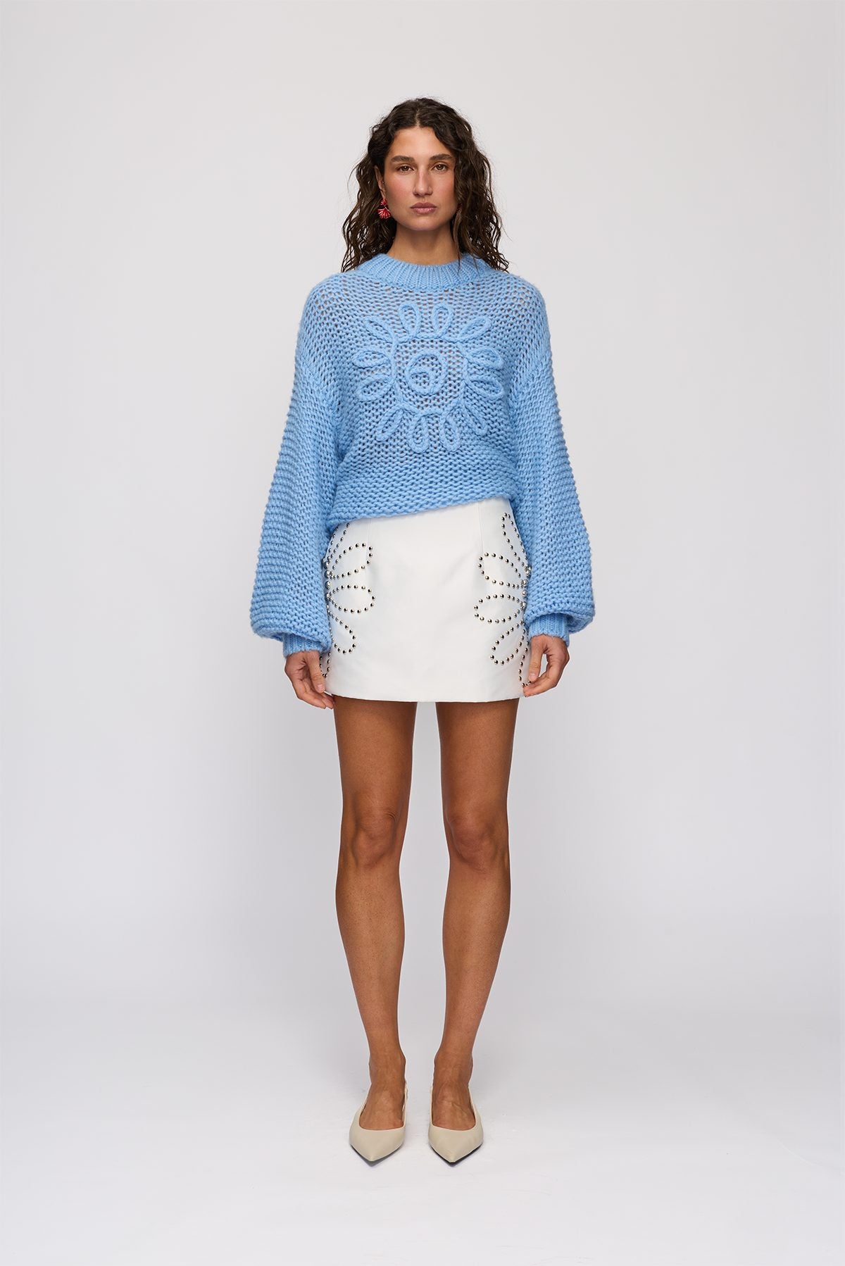 Seda Mini Skirt in Ivory by The Wolf Gang – front view styled with a blue knit